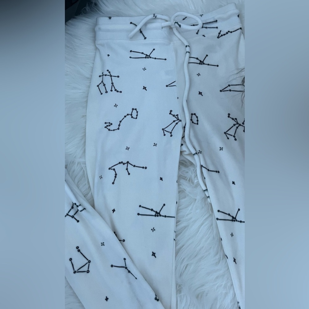 3 pairs of pants black, white with constellations and pink with other colors